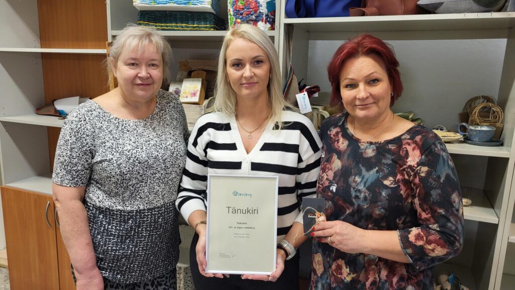 Tänukirjaga poseerivad tegevusjuhendajad Malve ja Tiivi ning vanemtegvusjuhendaja Kätlin.