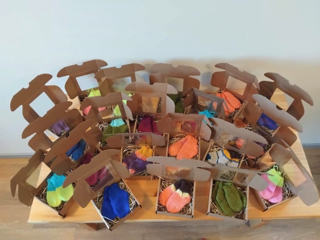 Laual on rida kootud sokkidega täidetud kinkekarpe. Karbid on avatud.