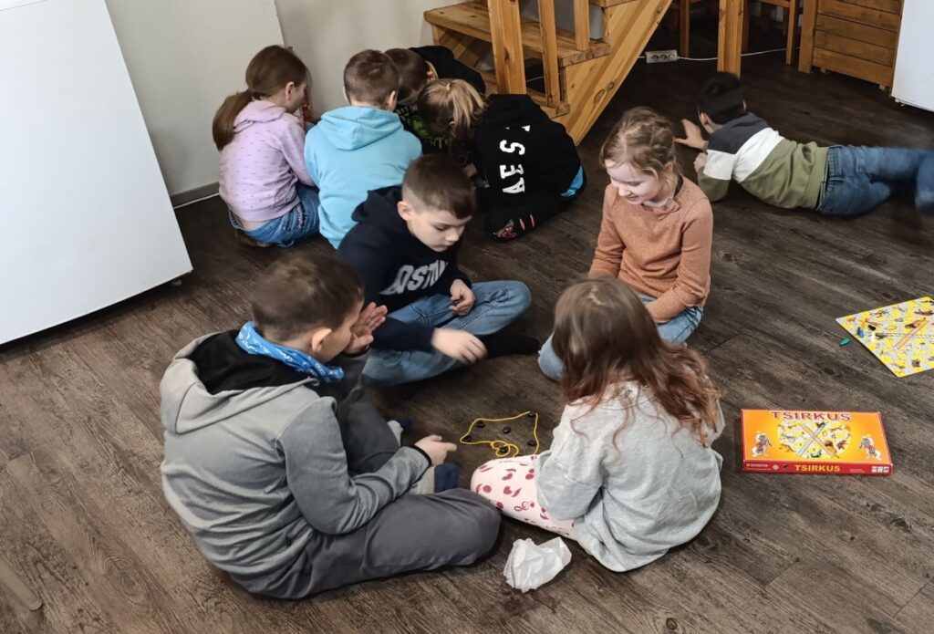 Lapsed istuvad gruppidena maas ja mängivad.