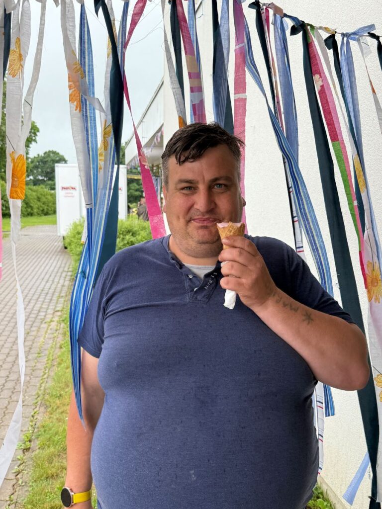 Mees sööb jäätist ja naeratab.