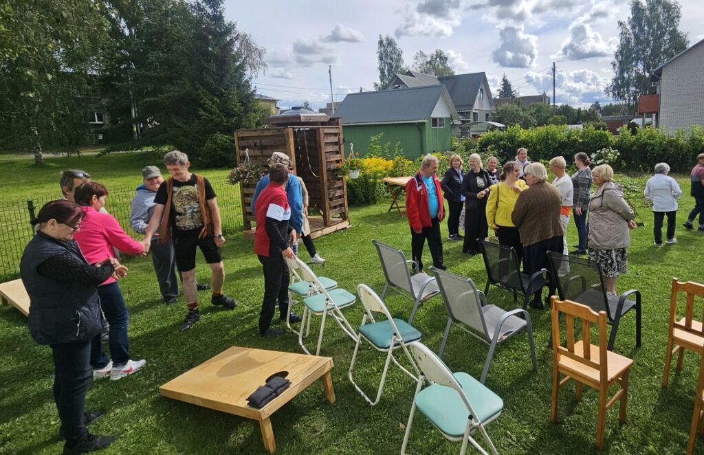 Inimesed kogunevad Jõgeva Allika kodu hoovi avatud uste päeval, suhtlevad ja tervitavad üksteist.