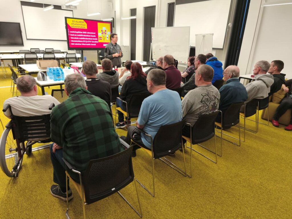 Rühm inimesi kuulab päästekeskuses kriisikoolitust klassiruumis.