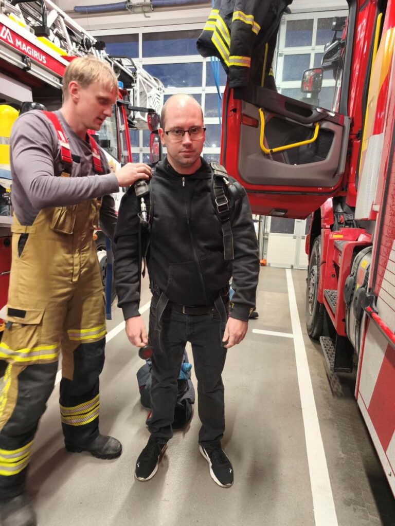 Päästja aitab külastajal selga panna päästevarustust päästekomandos