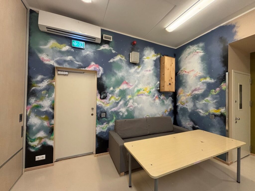 Valmis galaktika seinamaal väikerühma toas, ees diivan ja laud.