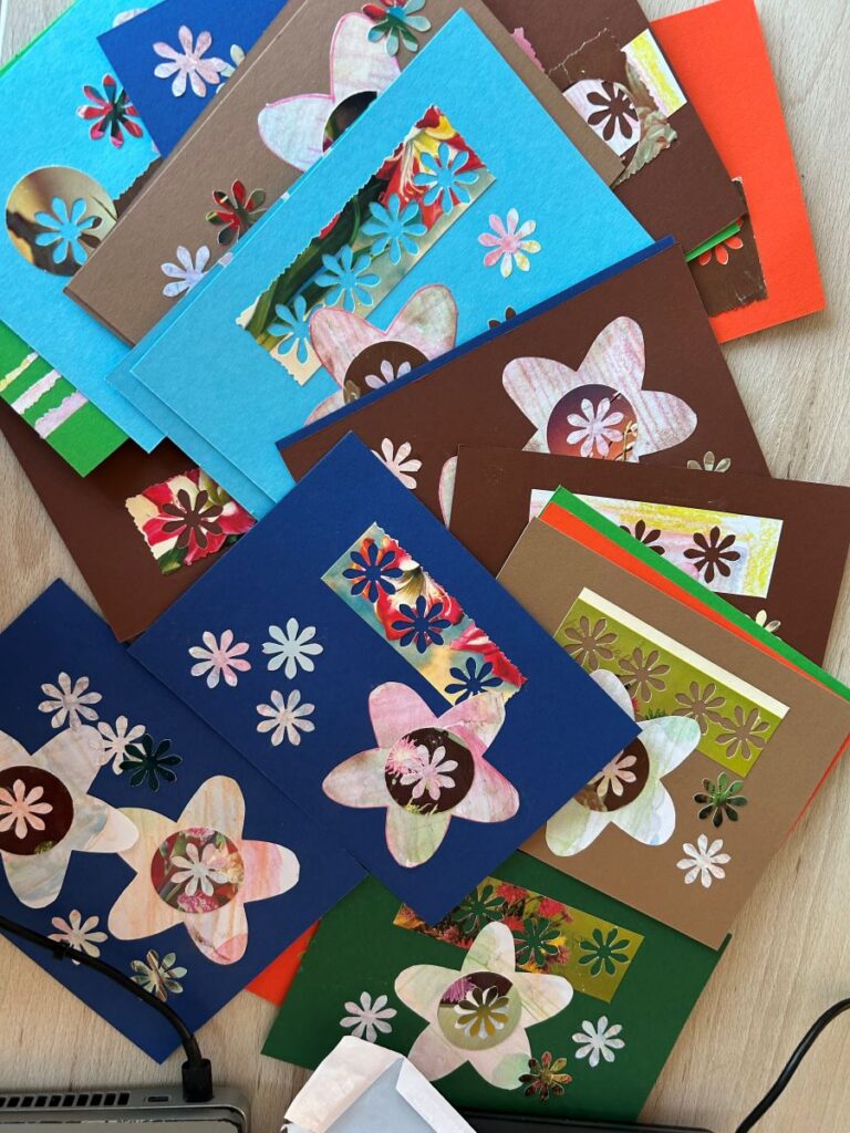 Laual on värvilised käsitsi tehtud õnnitluskaardid lillemotiividega.