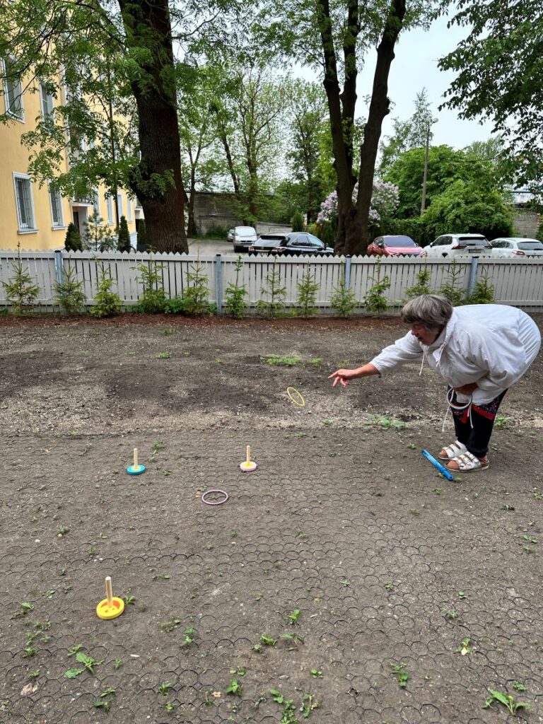 Õues elanik viskab rõngaid pulga otsa.
