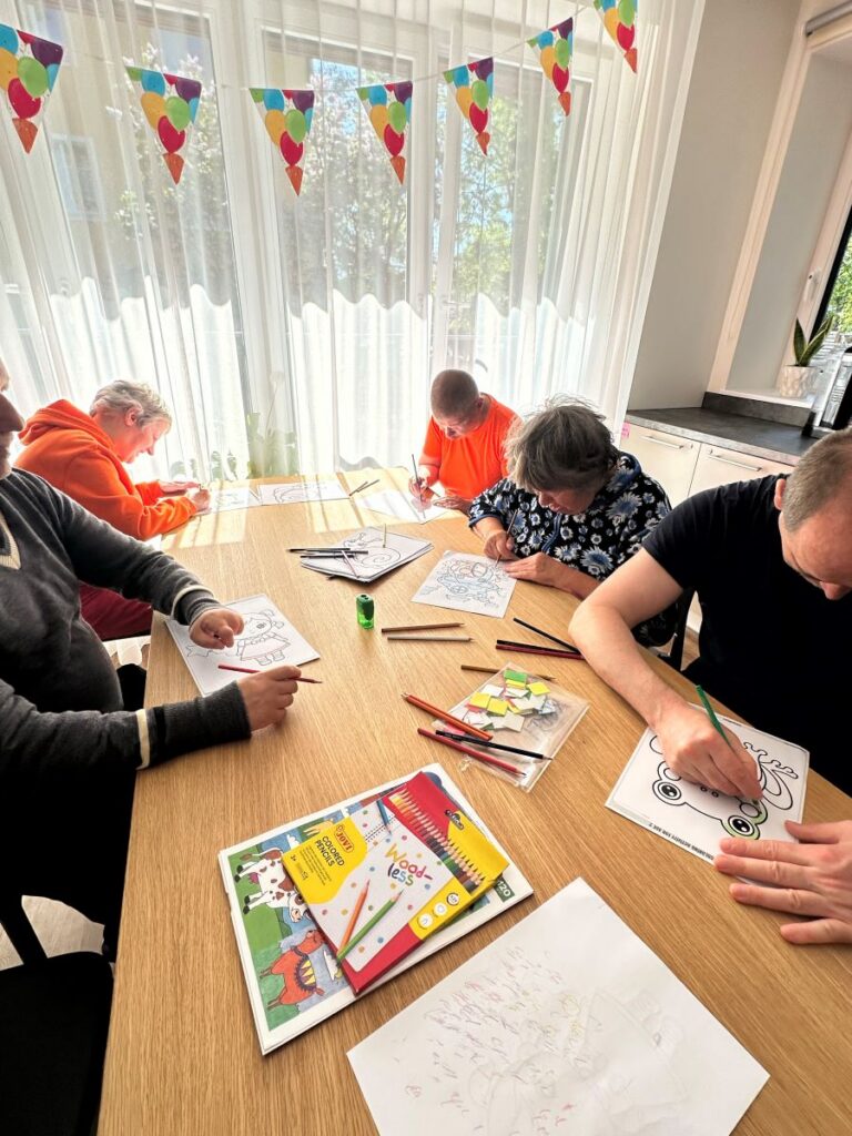 Elanikud laua ääres värvivad pilte.